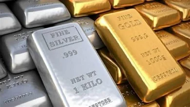 सोने और चांदी के सिक्के व बार दिखाते हुए गिरते हुए गोल्ड और सिल्वर प्राइस का ग्राफ