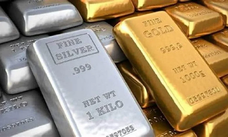 सोने और चांदी के सिक्के व बार दिखाते हुए गिरते हुए गोल्ड और सिल्वर प्राइस का ग्राफ