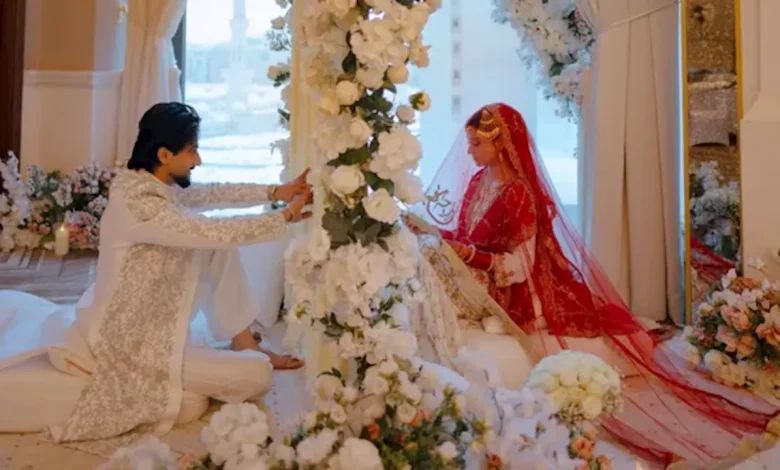 मिस्टर फैजू फैसल शेख सफेद शेरवानी में और उनकी दुल्हन लाल जोड़े में निकाह की तस्वीर में
